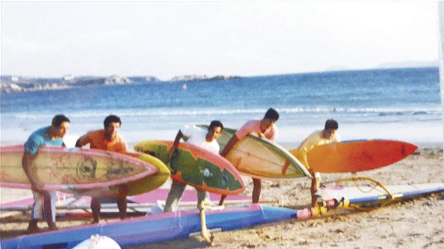 Pepe Solla vestido de naranja y su amigo Juan, de azul, en el verano de 1990 con tablas de windsurf. // Faro