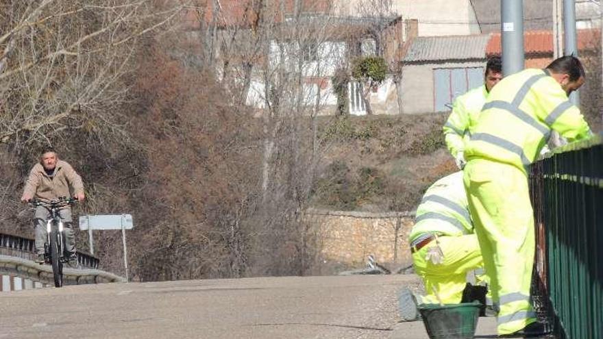 Operarios pintando la barandilla del puente de Santa Croya.