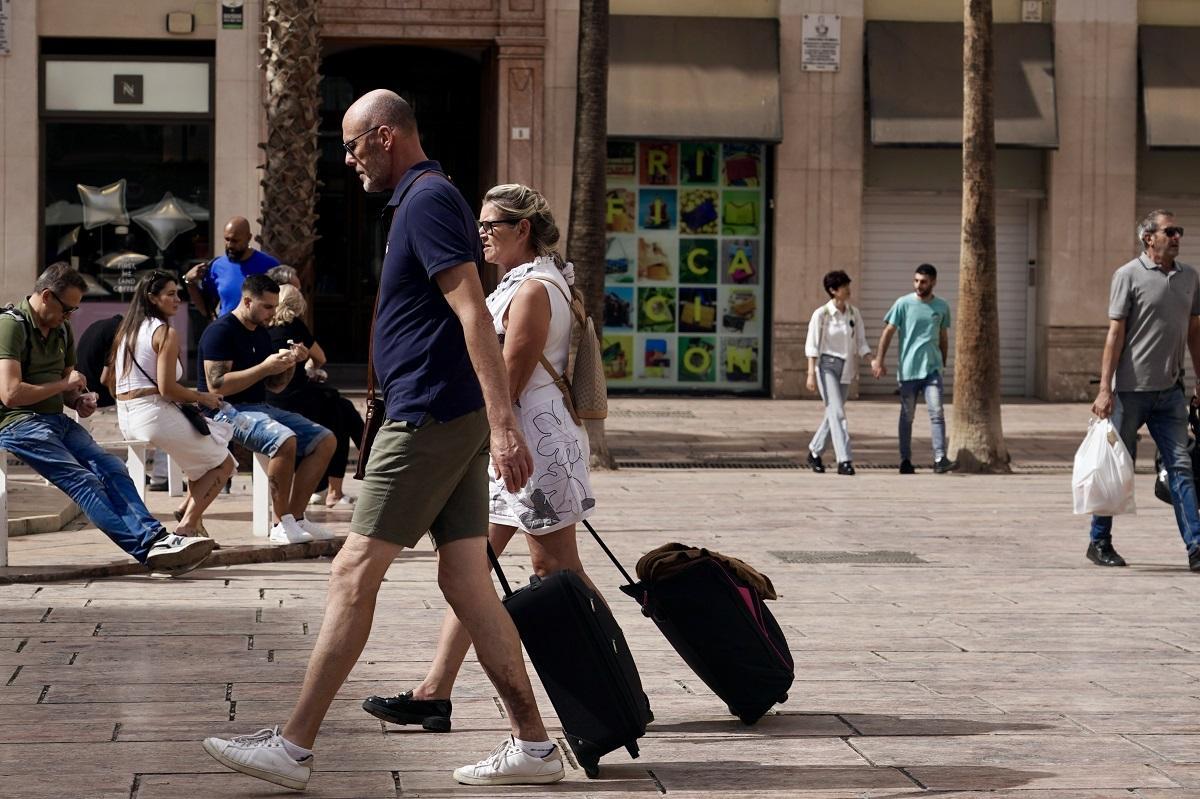 Turistas con sus maletas en el Centro de Málaga.