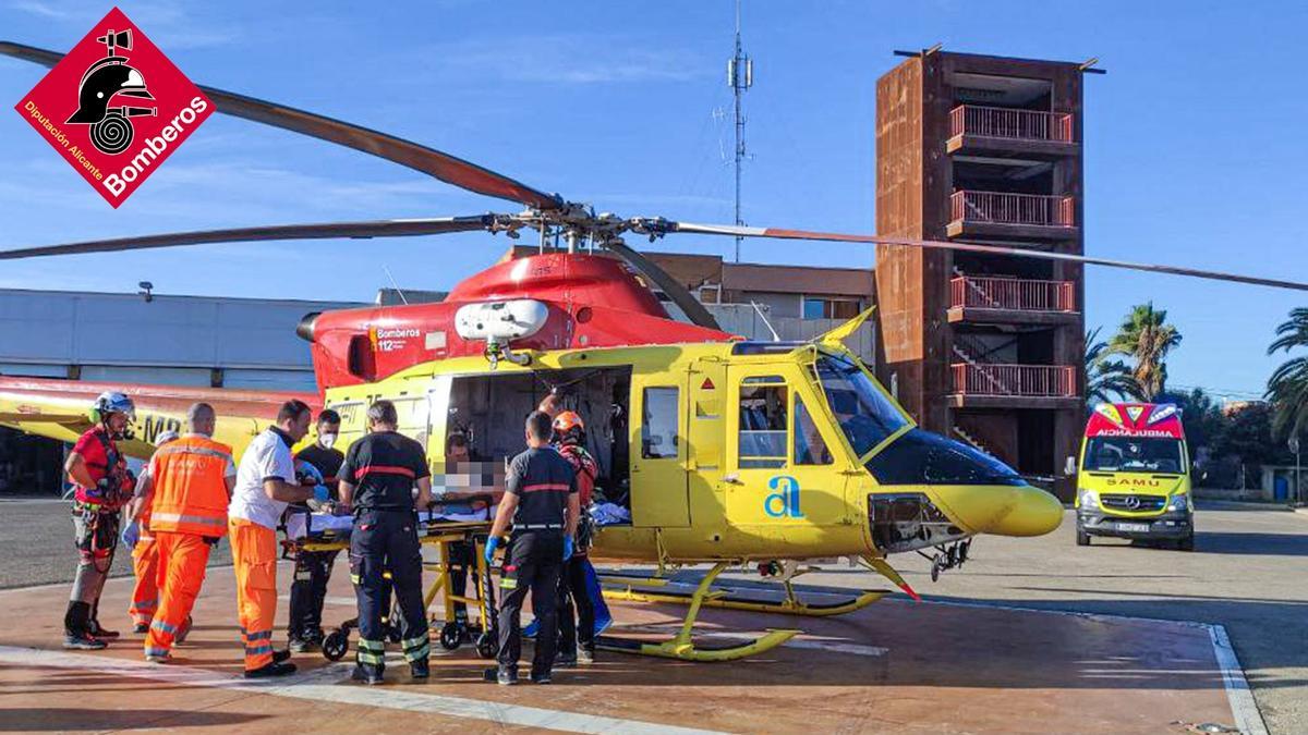 Traslado de la mujer accidentada desde el helicóptero hasta la ambulancia en el parque de bomberos de Dénia.