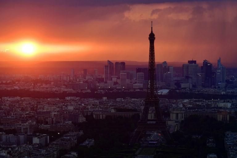 Torre Eiffel y el distrito comercial de La Défense al atardecer / AFP PHOTO / Philippe LOPEZ