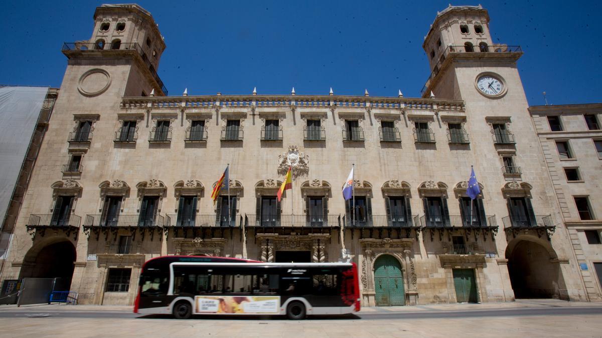 Un autobús urbano pasando por delante del Ayuntamiento de Alicante