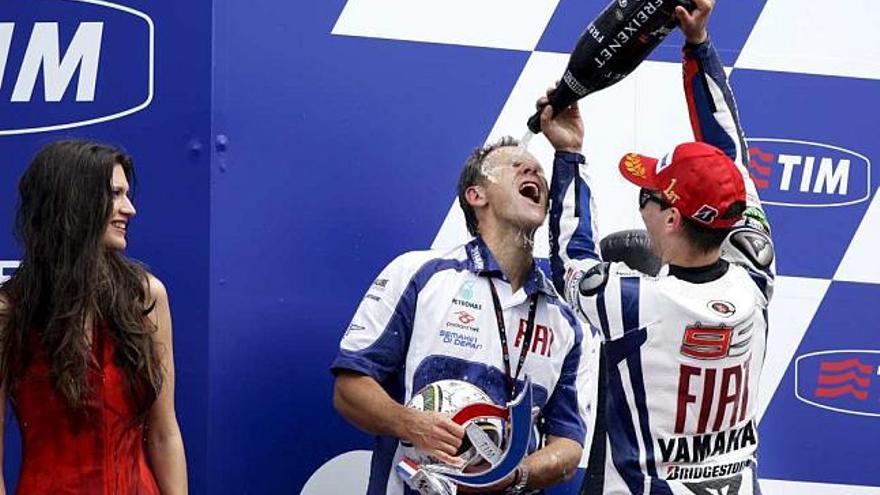 Lorenzo celebra el triunfo en el podio con un compañero del equipo.
