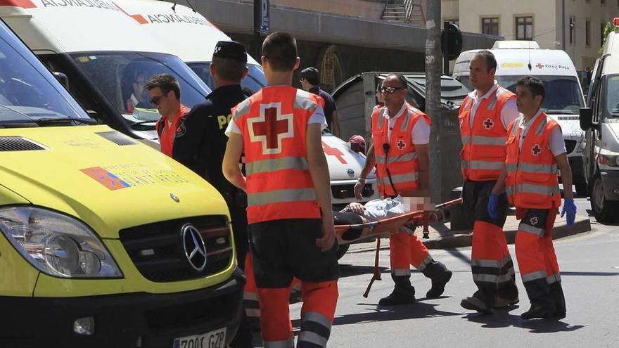 Una joven es trasladada en camilla hasta el hospital portátil de Cruz Roja, detrás de El Corte Inglés. pepe valero