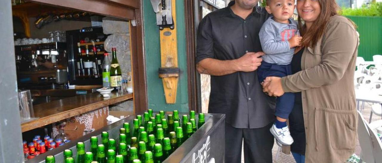 César Casal Franco y su mujer, Beatriz Zuazua-Azcárate, con su hijo Jacobo, en el exterior del local.