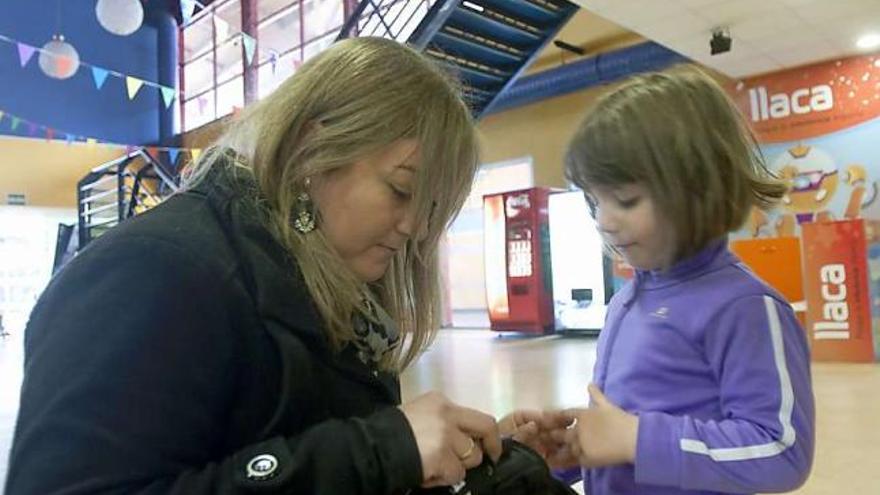 María del Valle mide el nivel de azúcar de su hija Paula Mon, ayer, en el Palacio de los Niños de Oviedo.