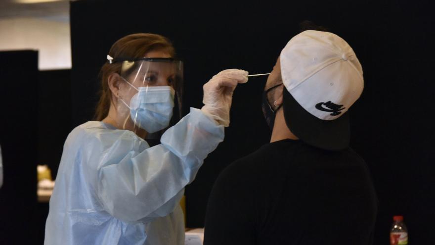 Una trabajadora sanitaria realiza un test de antígenos a un joven.