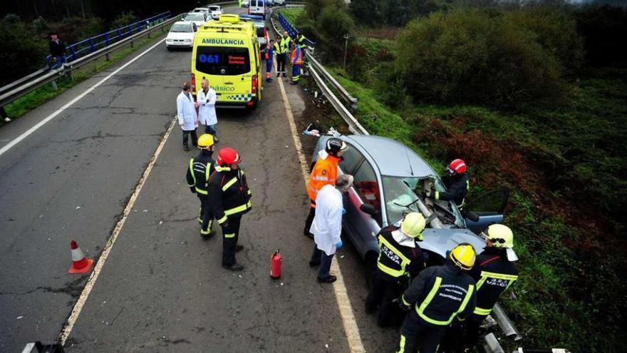 Los servicios de emergencias realizando la excarcelación de la conductora en Godos. // Iñaki Abella