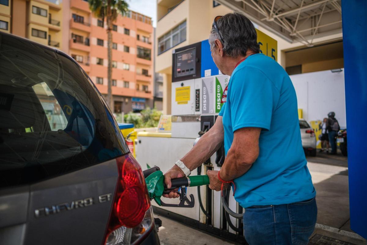 Un conductor pone gasolina en una estación de servicio.