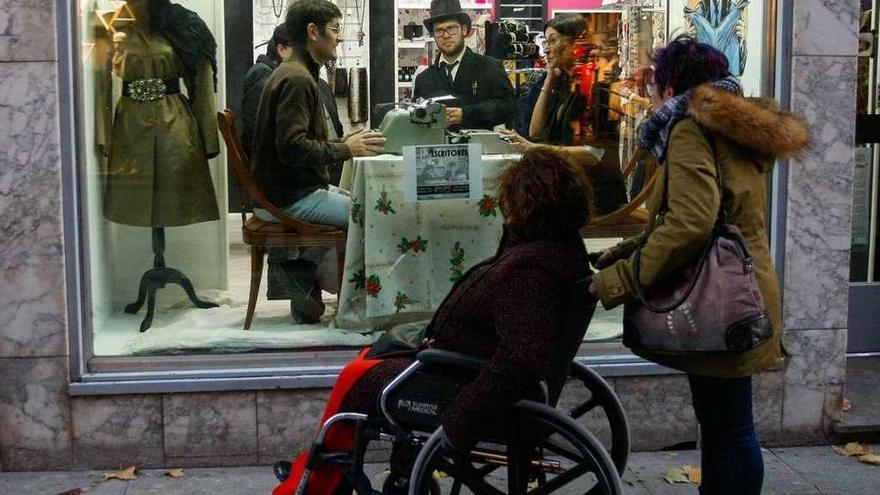 Varias personas observan a los dos escritores en el interior de un escaparate en Santa Clara.