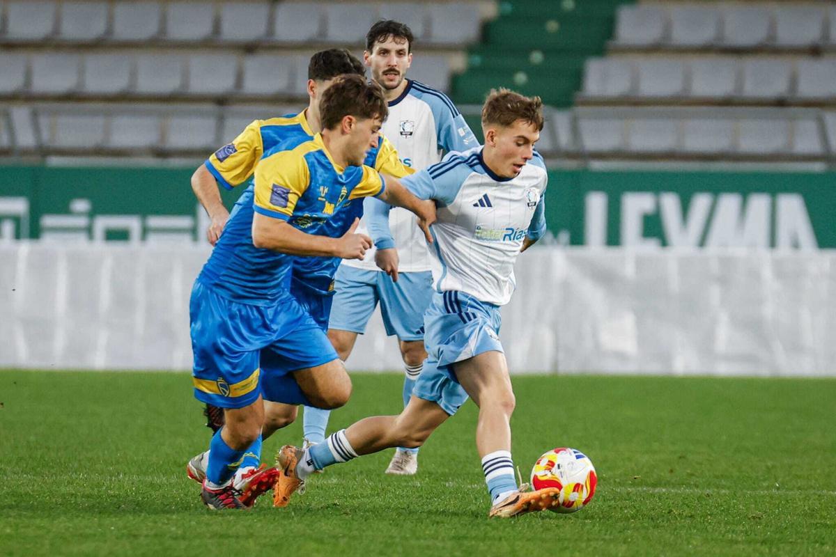 Lucas Camba protege el balón ante la defensa asturiana.