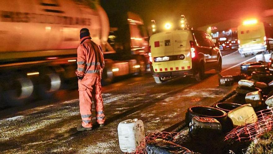 En un marge, bidons i pneumàtics que havien estat posats a la carretera