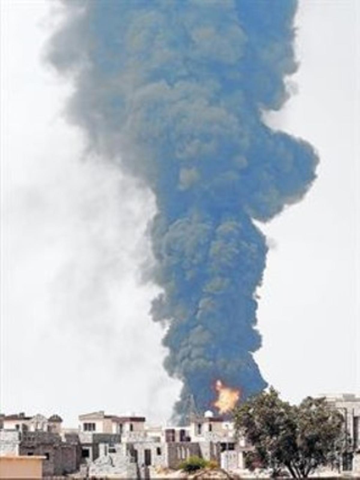 Una columna de fum causada per l’incendi als dipòsits de combustible s’alça sobre Trípoli, ahir.
