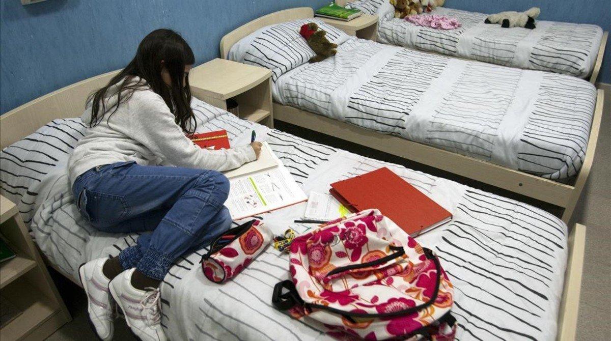 Una joven, en una imagen de archivo,  tumbada en la cama en un centro de acogida.