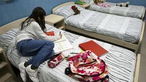 Una joven, en una imagen de archivo,  tumbada en la cama en un centro de acogida.