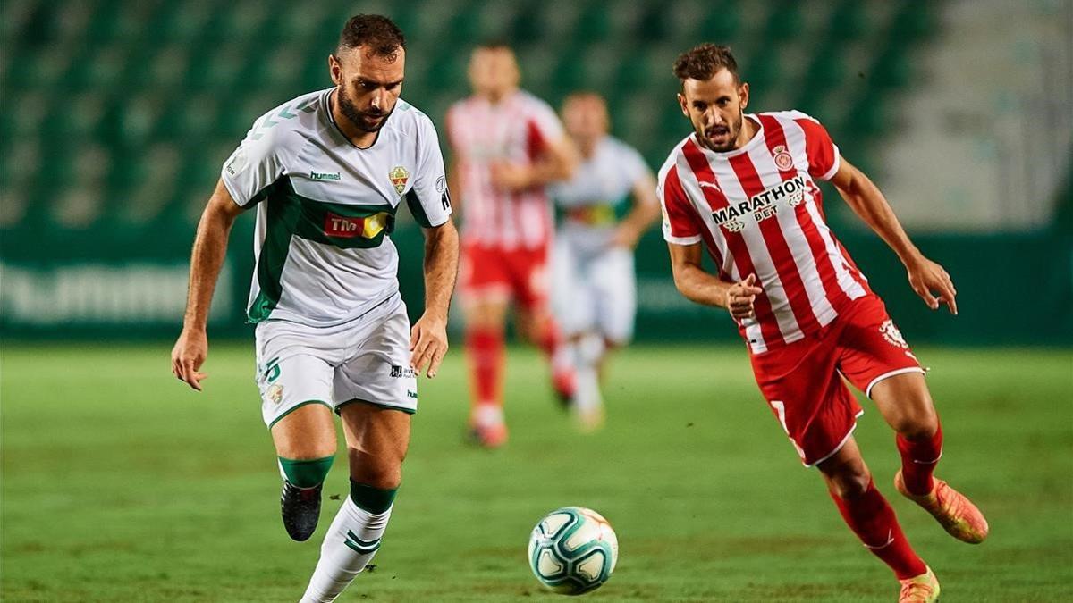 Verdú persigue a Stuani en el Martínez Valero en la ida del play-off de ascenso a Primera.