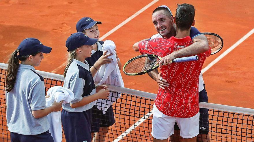 Djokovic (de espaldas) y Troicki se abrazan ante varios recogepelotas durante el Adria Tour.