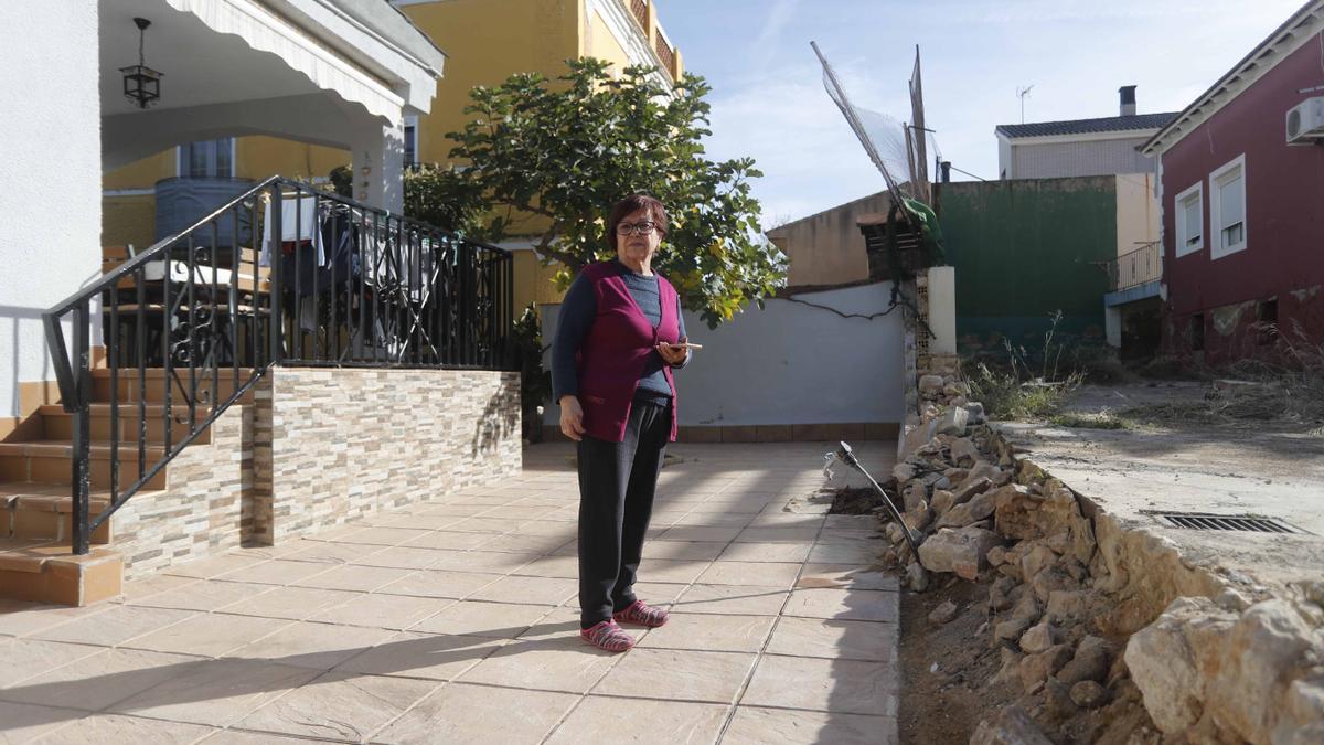 Clara junto al muro trasero de su casa, que se destrozó por completo, ya una vez una empresa ha retirado los restos