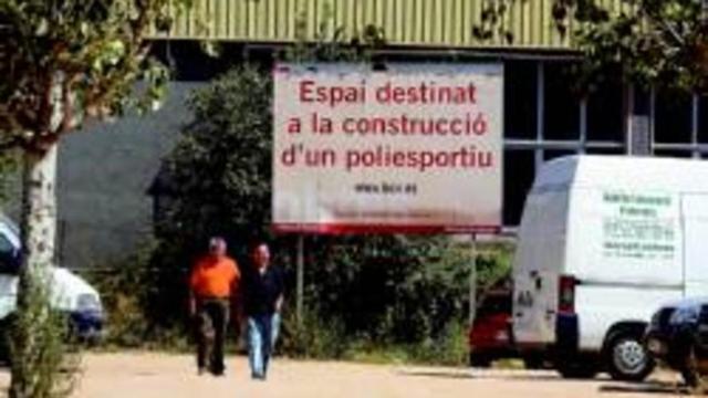 El solar donde está previsto construir el polideportivo de Canyelles con el cartel que lo anuncia al fondo.
