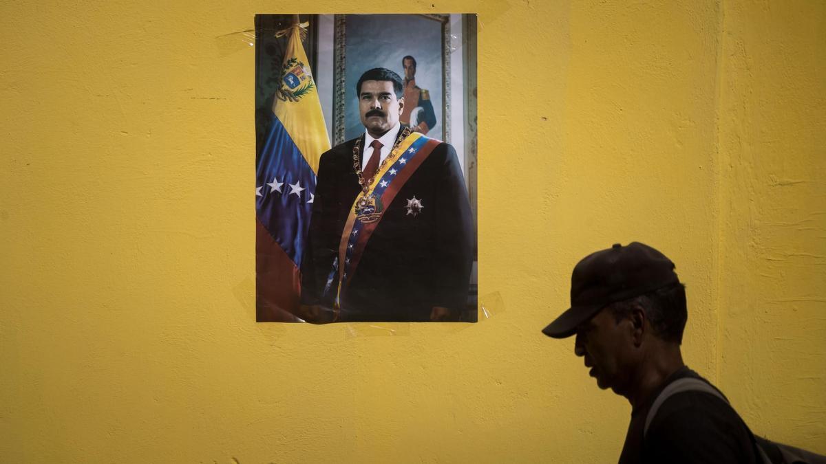 Un hombre pasea frente a una imagen de Nicolás Maduro en Venezuela.