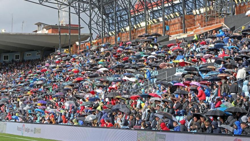 Aficionados con paraguas y chubasqueros durante un partido del Celta