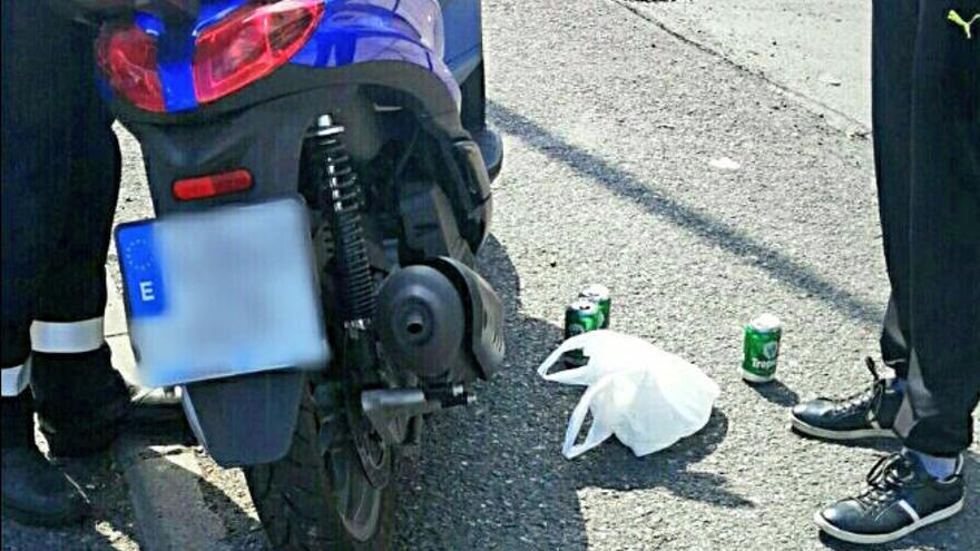 La motocicleta y las latas de cerveza que llevaba el empresario detenido.