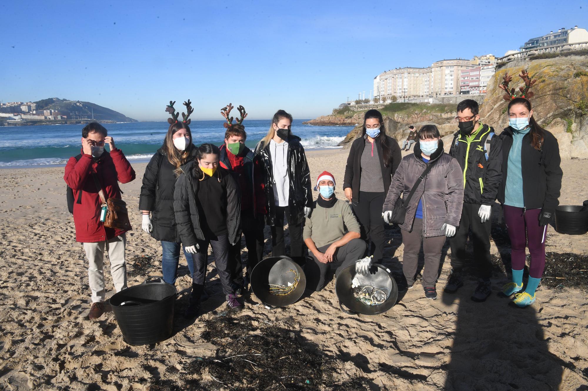 Socios y socias de Down Coruña limpian la playa del Orzán