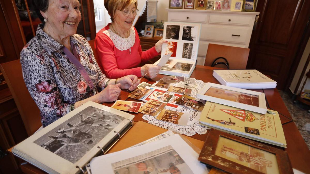 Por la izquierda, Teresa Vázquez y su hermana Marisa, en el salón de la casa  familiar, en Sotrondio, entre fotografías y recuerdos de la carrera de Cundi.