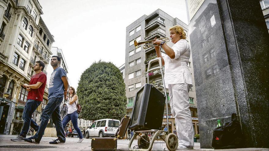 Dace Apsite, artista callejera, interpreta un tema con su trompeta en la calle Pelayo.