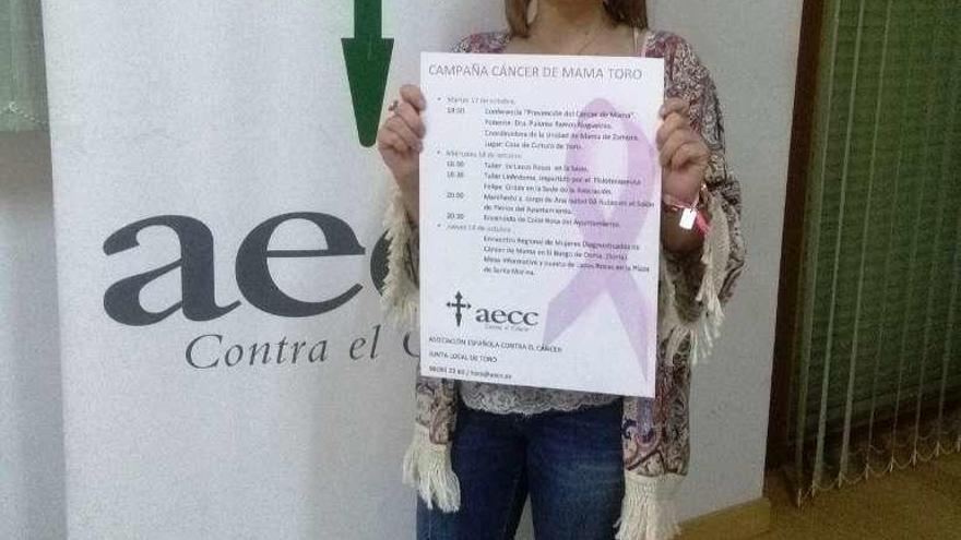 María Hernández muestra el cartel de actos programados.