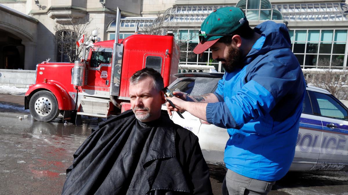 Isaac Maltin, a barber from Medicine Hat, Alberta, cuts hair as truckers and their supporters continue to protest coronavirus disease (COVID-19) vaccine mandates, in Ottawa, Ontario, Canada, February 7, 2022. REUTERS/Patrick Doyle