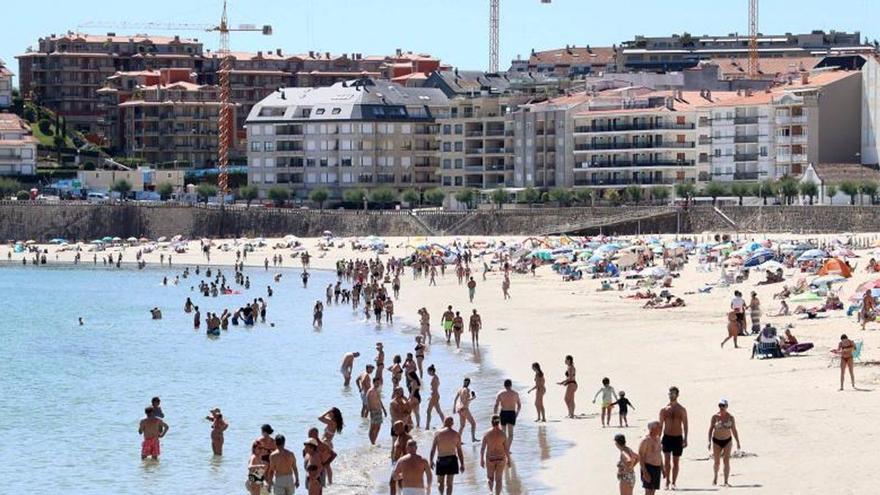 Varios edificios, algunos de ellos en construcción, ante la playa de Silgar, en Sanxenxo.