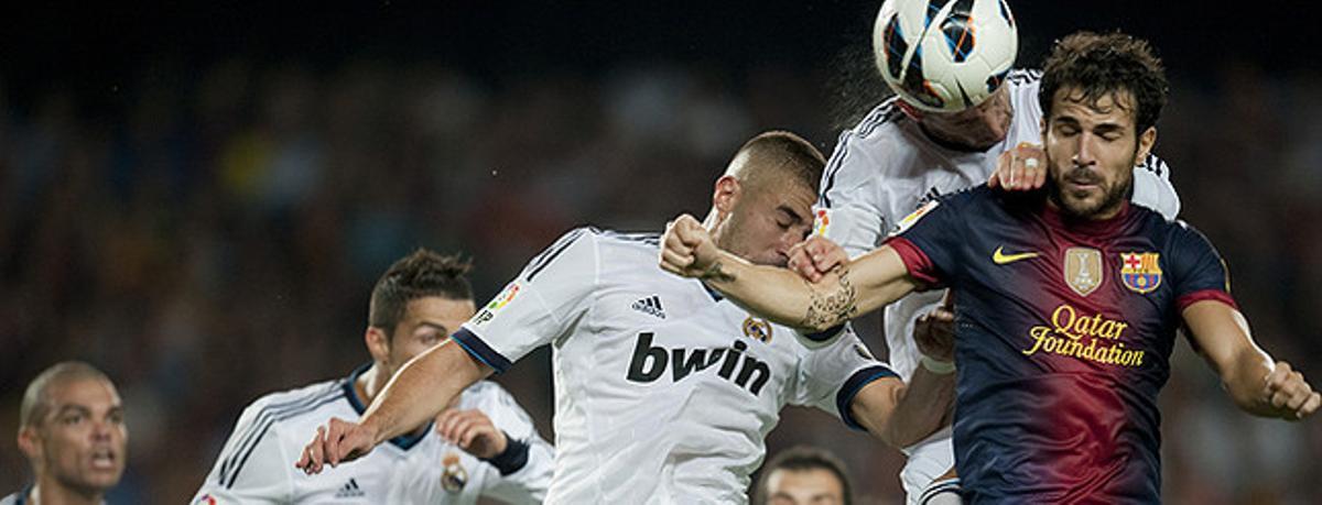 Cesc, assetjat pels jugadors del Madrid.
