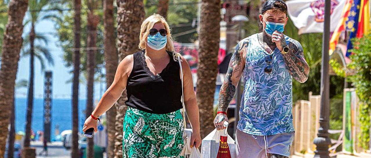 Una pareja deturistas caminapor Benidorm.