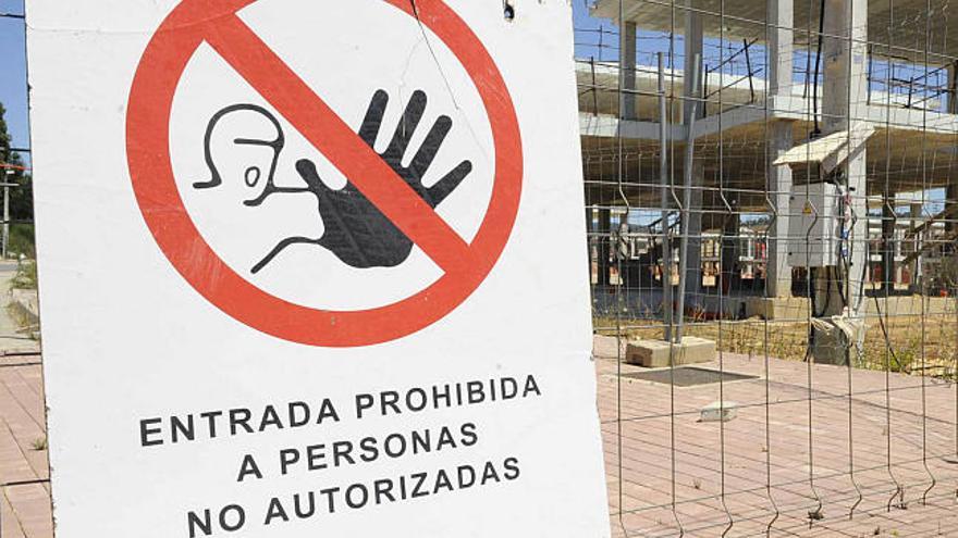 Un cartel prohíbe el paso a una construcción en Miño. / víctor echave