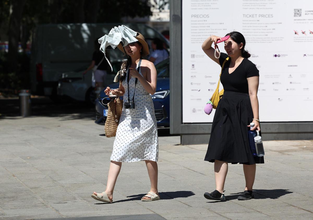 Archivo - Una mujer se refugia del calor con un paraguas durante una segunda ola de calor.
