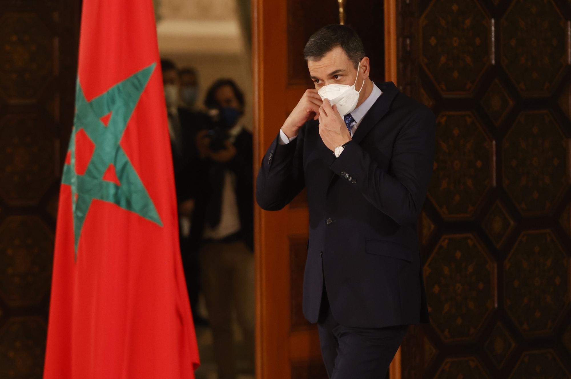 Pedro Sanchez junto a una bandera de Marruecos