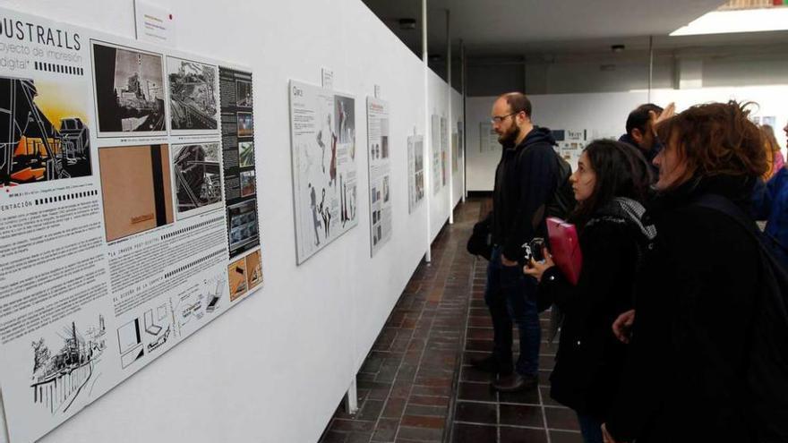 Varios asistentes observan el panel de &quot;Industrails&quot;, el trabajo realizado por el asturiano Damián González.