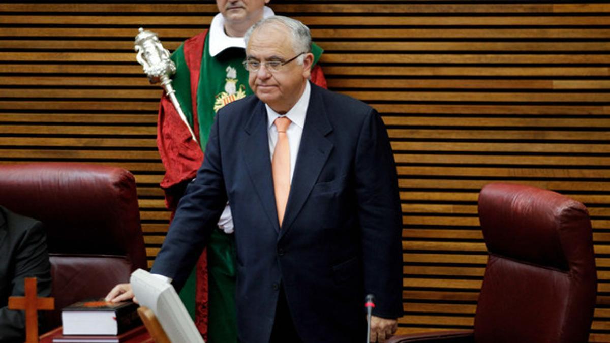Juan Cotino jura su nuevo cargo de presidente de Les Corts durante la sesión constitutiva de la octava legislatura, en la que ha estado presente un crucifijo (abajo, a la izquierda).