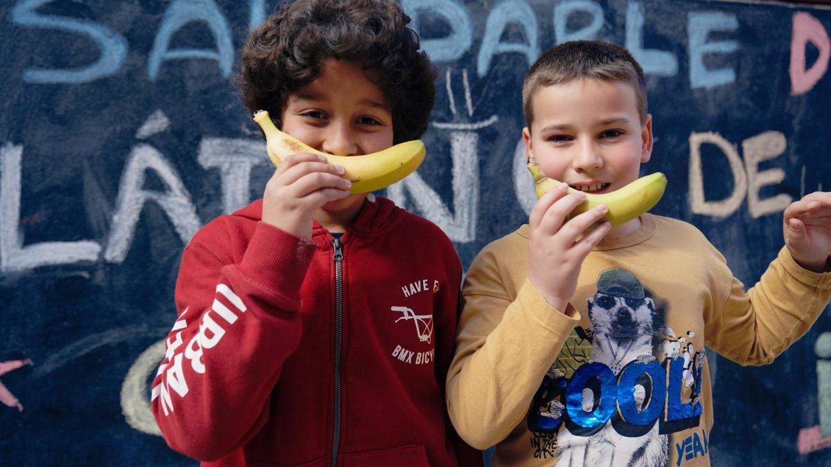Dos alumnos del colegio sujetan plátanos de Canaria.