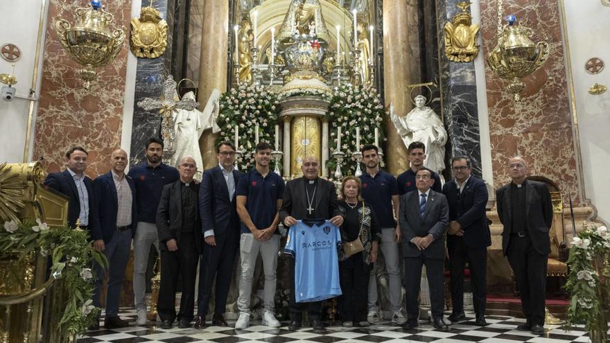 Una representación del Levante UD visitó la Basílica de la Virgen de los Desamparados para ofrecer a la patrona de València la camiseta conmemorativa del centenario de su coronación con la que la entidad levantinista ha querido sumarse a los actos del año Jubilar Mariano. | M.Á.MONTESINOS