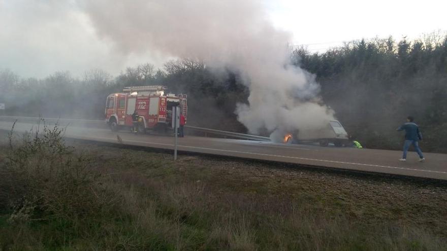 Los bomberos intervienen en la extinción del fuego en el coche