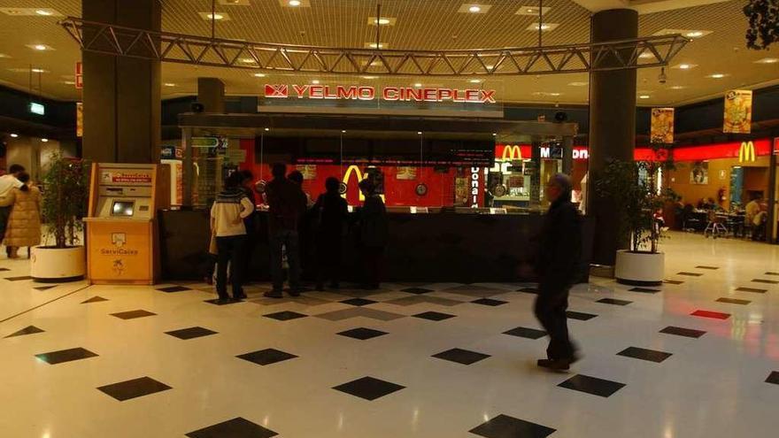 Varias personas aguardan cola en la taquilla de un cine de A Coruña.