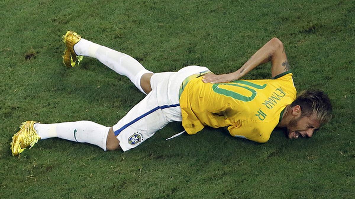 Neymar se retuerce de dolor sobre el césped del Castelao Arena trasrecibir un golpe de Zúñiga en la espalda