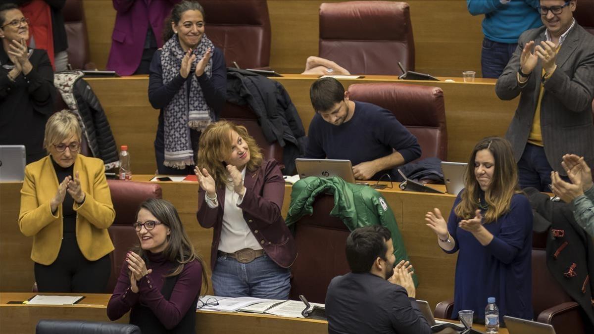 Diputados valencianos, entre ellos la vicepresidenta Mónica Oltra y el conseller de educación Vicent Marzà, aplauden tras la aprobación de la ley