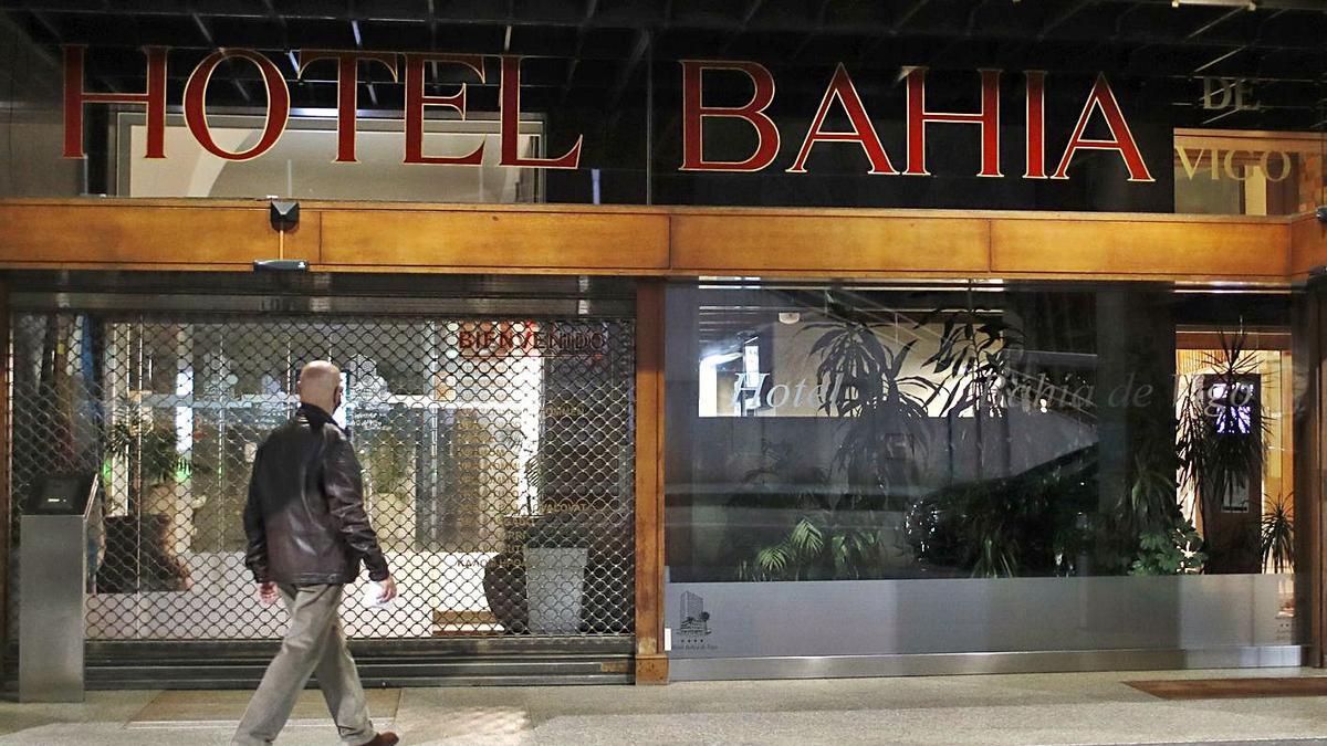 Un hombre observa la entrada del Hotel Bahía, que tiene la persiana bajada desde el viernes.   | // R. GROBAS