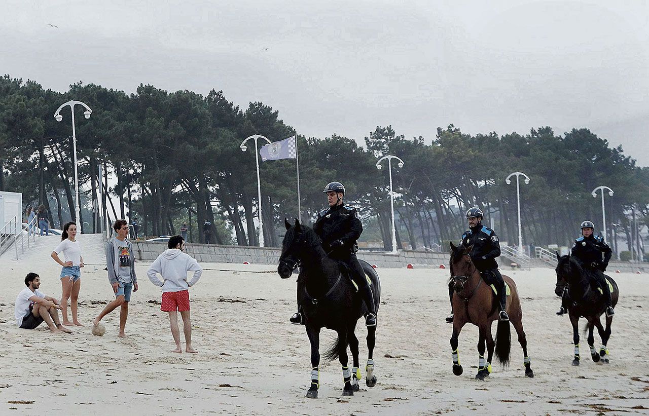 24-junio-Agentes de la Policía Local a caballo recorren ayer la playa de Samil para evitar que se prendiesen hogueras y reuniones masivas.jpg