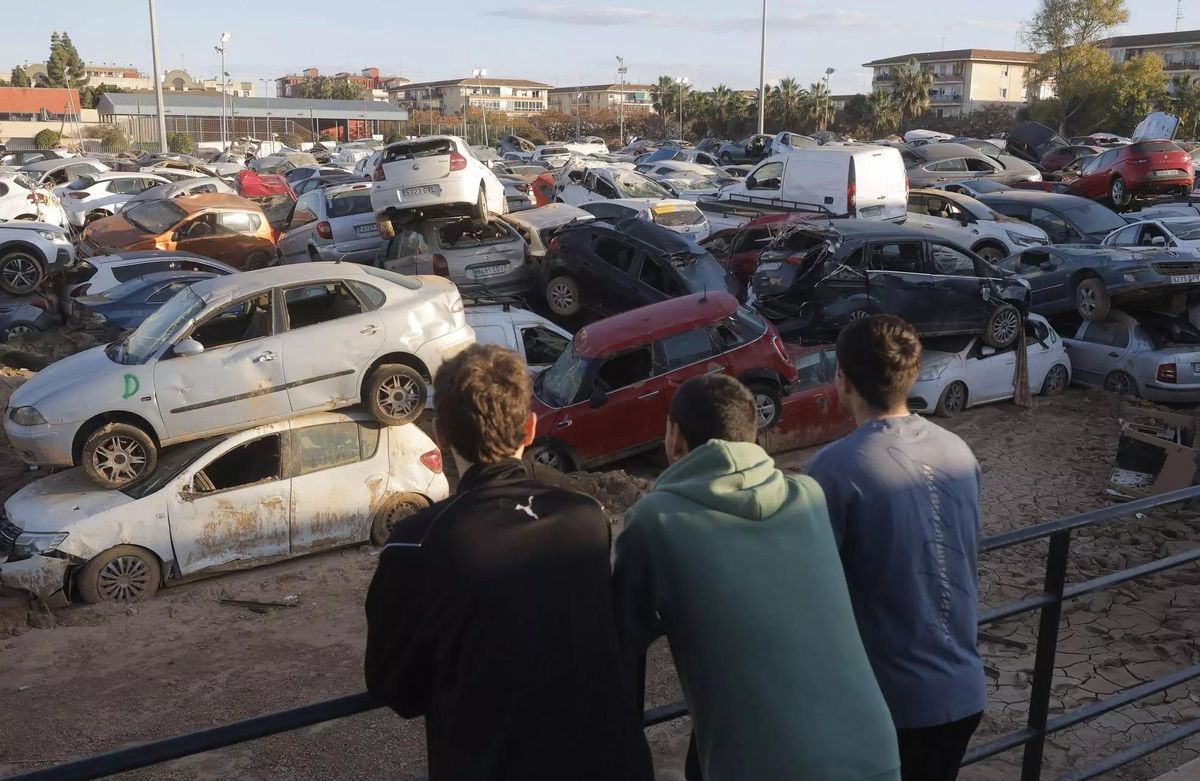 Varios jóvenes en el campo de fútbol de Benetússer reconvertido en campa, unos meses después de la dana.