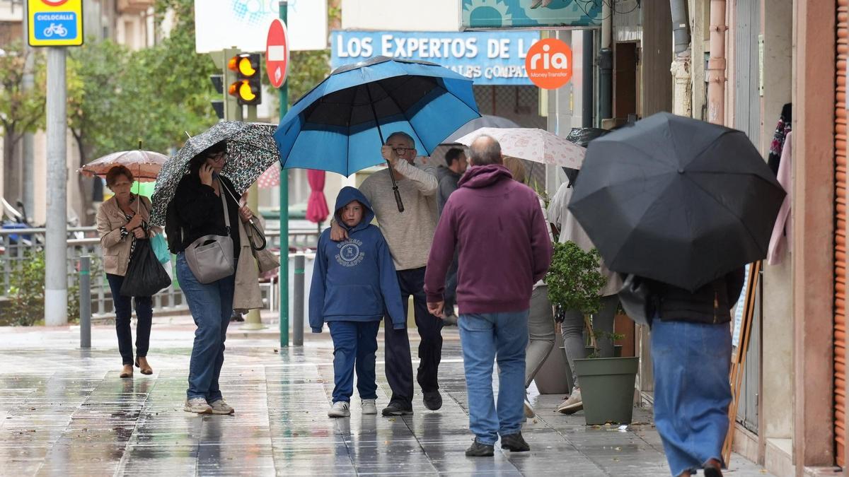 Personas pasean por el centro de la capital provincial durante una jornada lluviosa en una imagen de archivo.