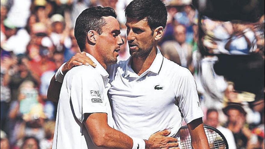 Djokovic y Bautista se abrazan al final del partido.